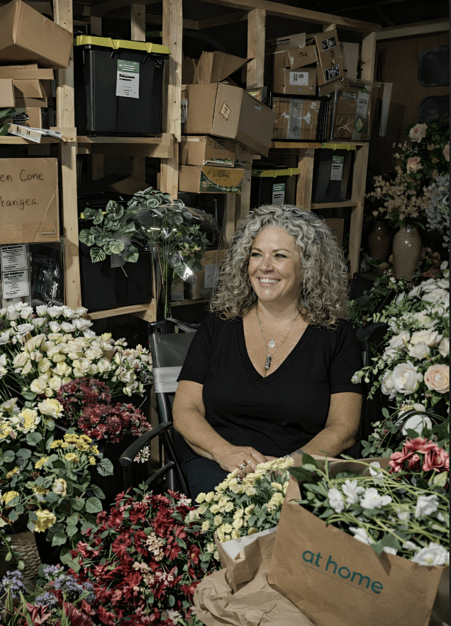 Smiling woman among flowers and storage boxes